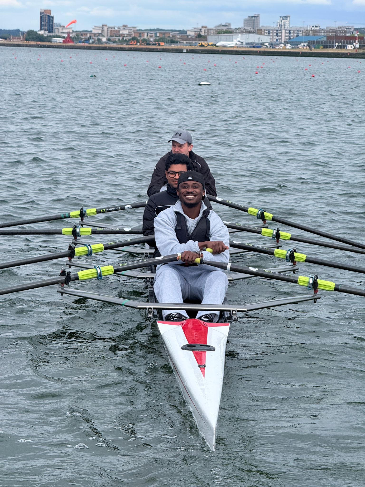 Gideon smiling while rowing with his crew